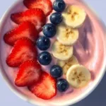 A vibrant fruit smoothie bowl topped with Greek yogurt and fresh fruits
