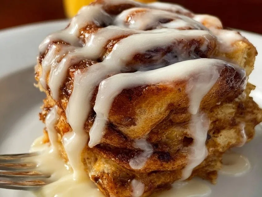 Fluffy Cinnamon Roll Pancakes topped with icing and served on a plate.
